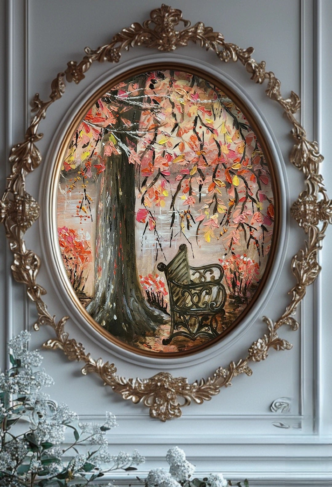 Decorative painting with a tree and bench in an ornate gold frame on a wall.
A painting featuring an empty bench under a lonely tree stump with overhanging autumn leaves branches with a flowing river in the background. Original fine artwork. Wall decor. Interior design and decorations for home office studio, cafe. Artwork modern art.