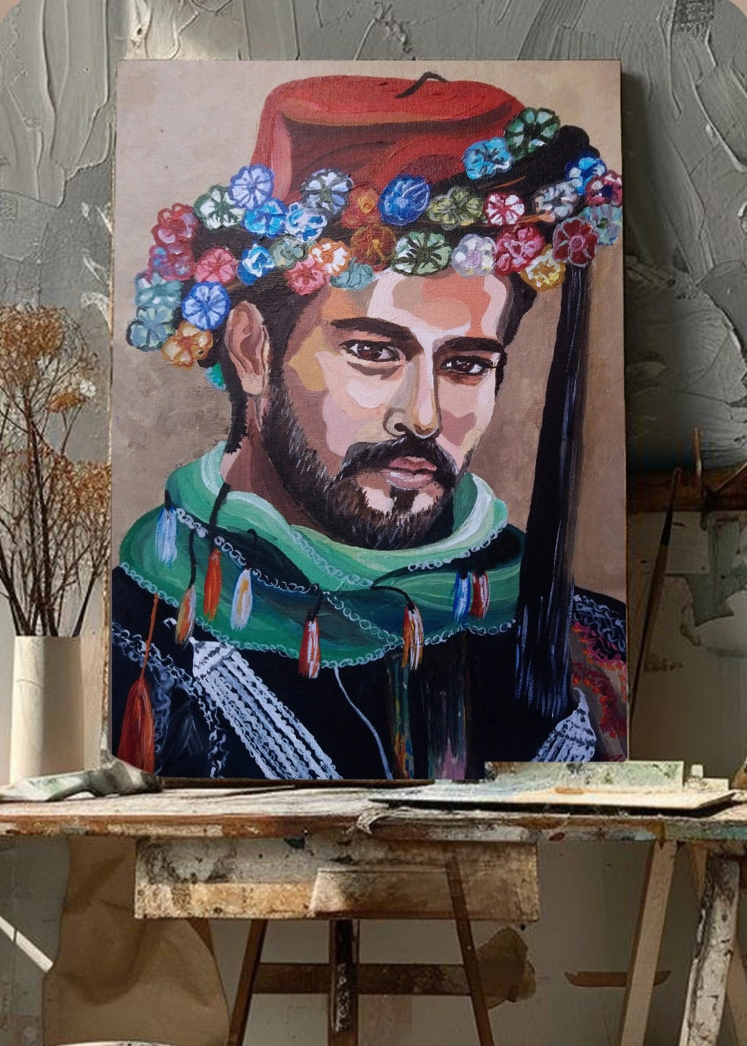 An original painting of a male figure with a red fez adorned with colorful flowers, a green scarf, and intricate embroidery, representing a blend of Anatolian cultural and traditional costume. Set in an art studio on an easel.  Artwork themes, wall art, home or office decor.