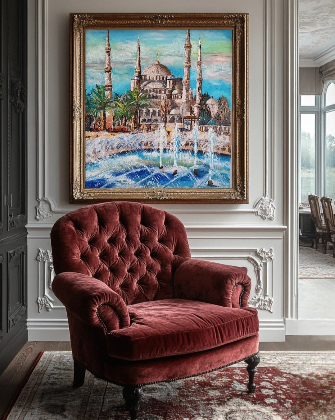 Red velvet armchair in a room with a large painting of a mosque on the wall. The Painting of the Blue Mosque in Istanbul with fountains and palm trees at the front. Wall artwork home decor.