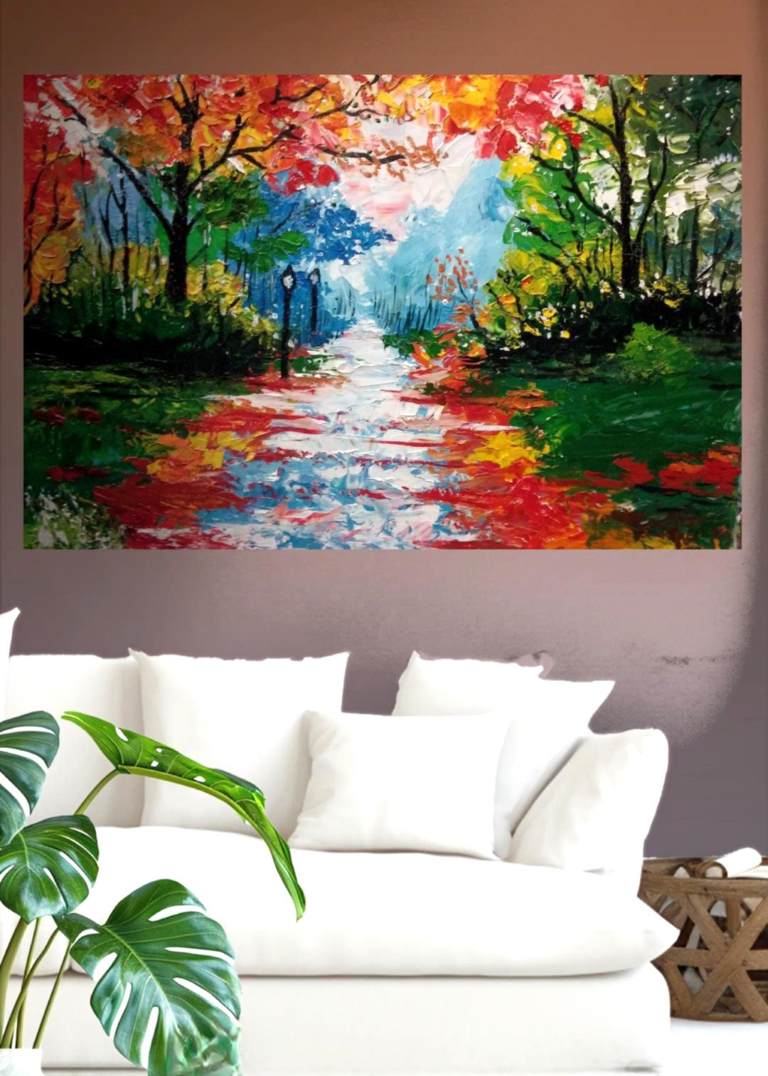 An original abstract painting of red, blue trees lining a pathway lit up by organic street lamps set over a white sofa in a modern living room. Bold pallet knife and brush strokes. Home decor. Wall art and art collectors.