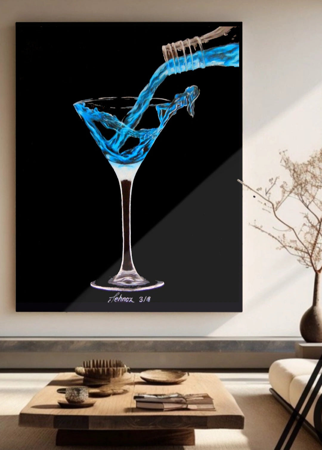 Framed artwork of a blue liquid being poured into a martini glass on a black background, displayed in a living room.